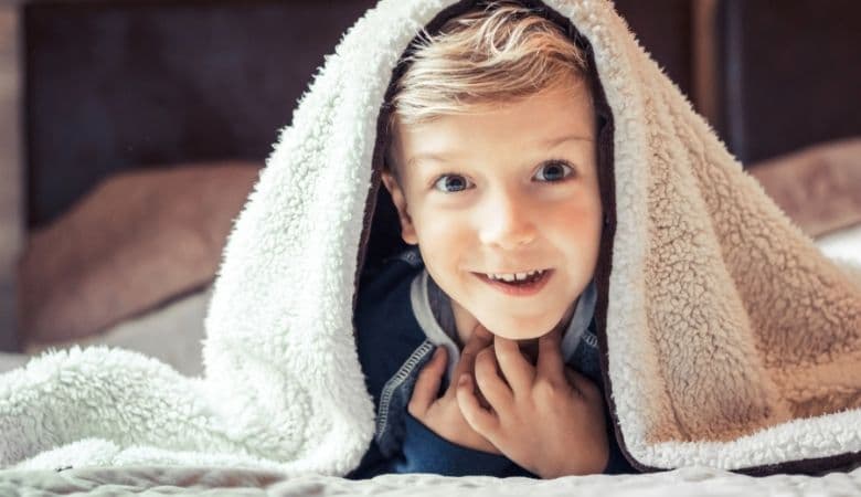 young kid with a blanket on the head