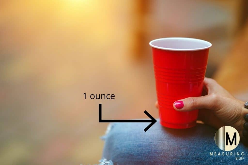 woman holding red plastic cup