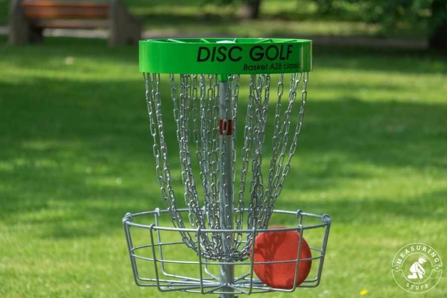 Disc golf basket with red disc inside