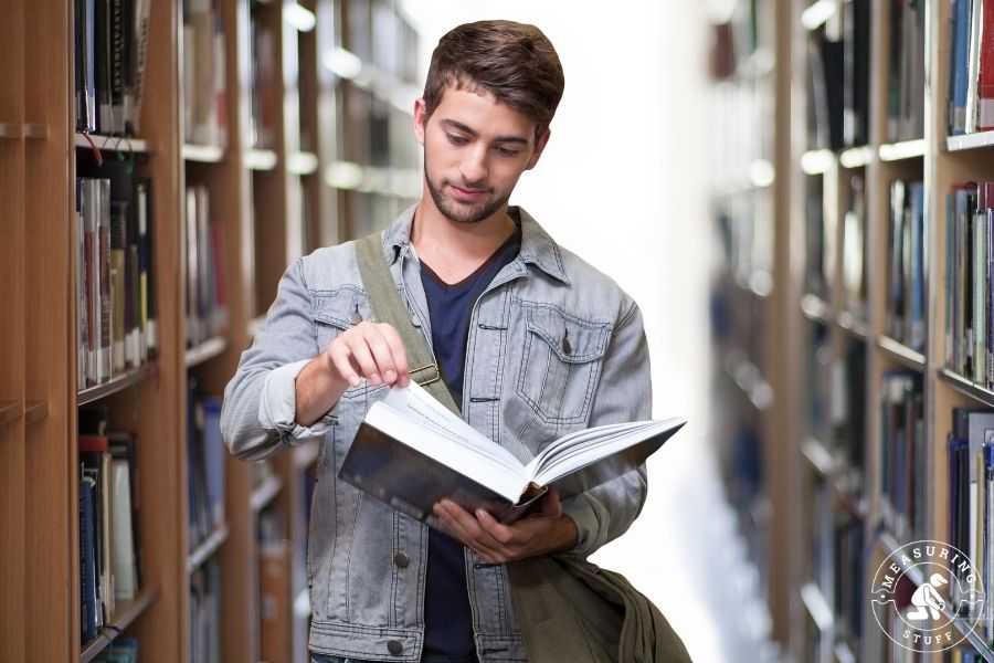 man reading a book in the library