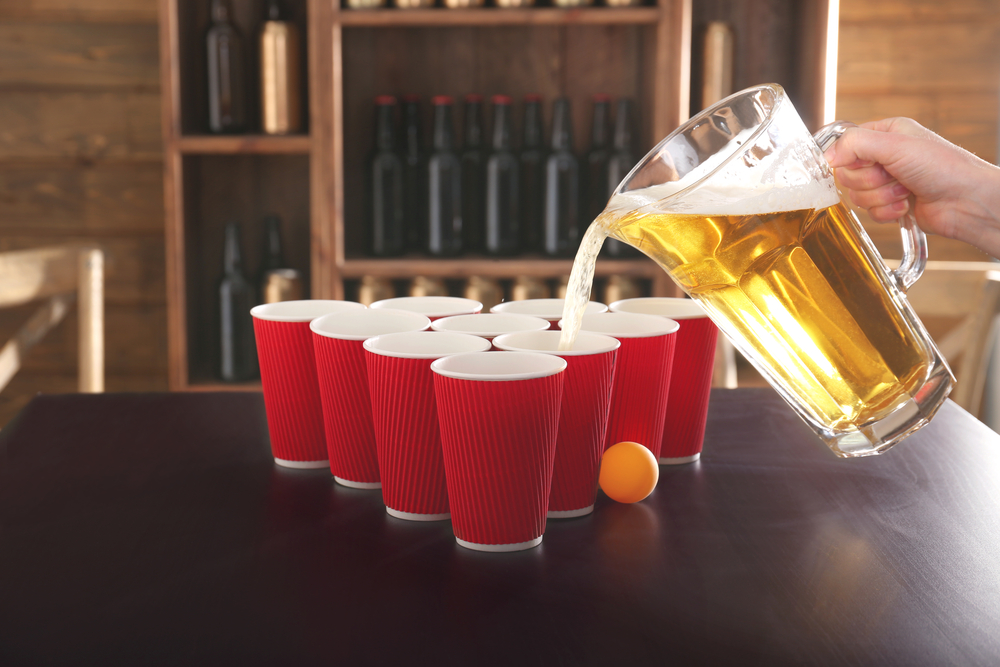 pouring beer into beer pong cups