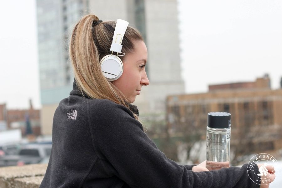 woman wearing headphones holding a water bottle