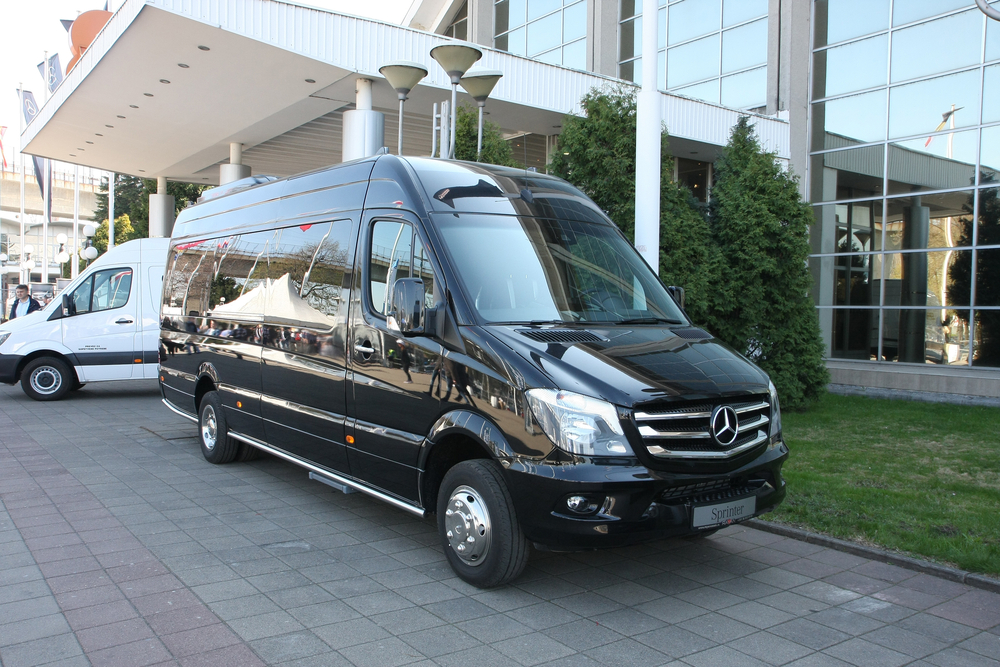 Black Mercedes Sprinter cargo van on sidewalk
