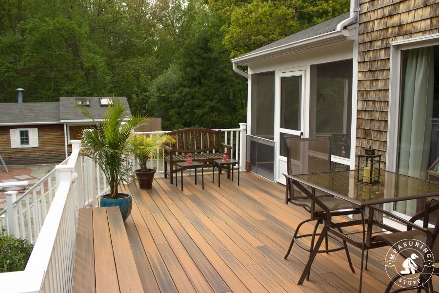 large wood deck with metal bench and table