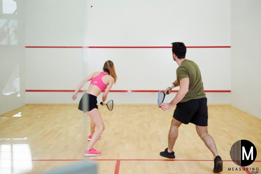 man and woman playing squash