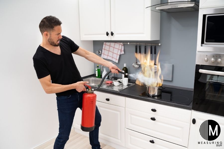 man extinguishing kitchen fire