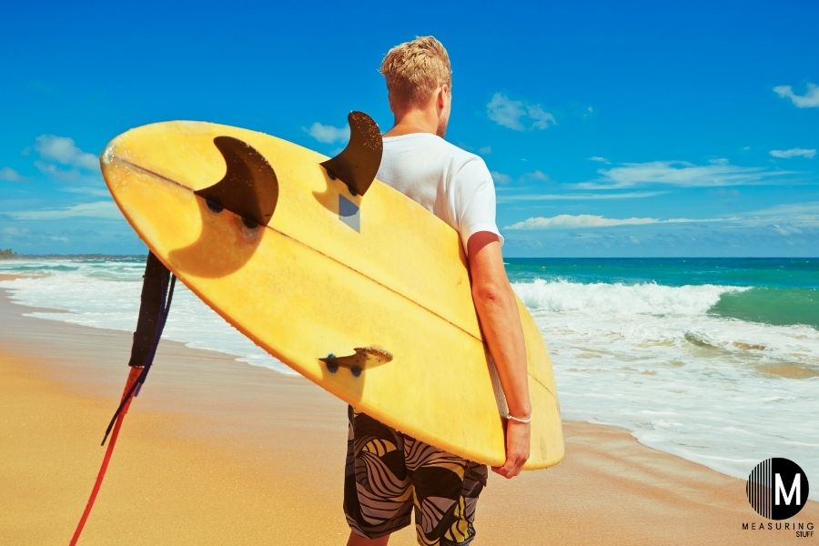 man holding yellow surfboard