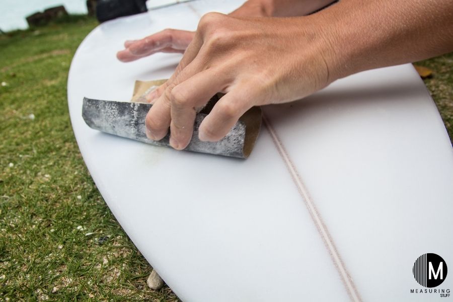 sanding a surfboard