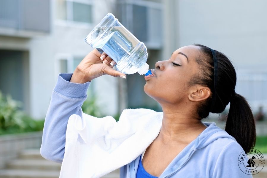 woman drinking from water bottle