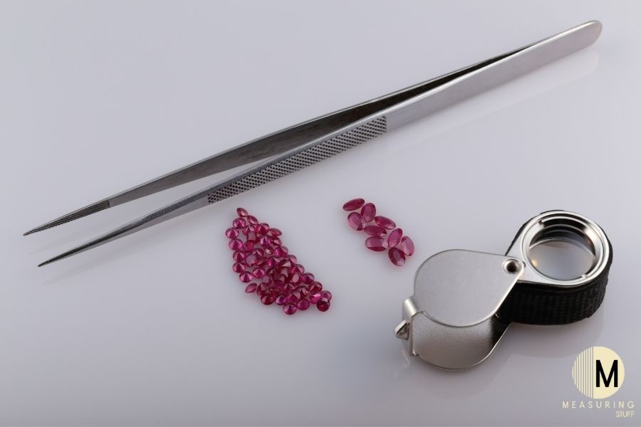 small rubies with tweezers and microscope
