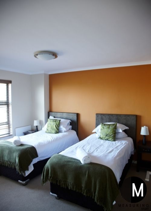 two twin beds with green pillows