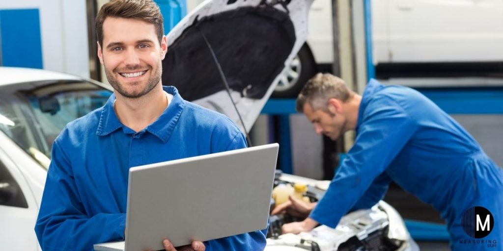 car mechanic holding laptop