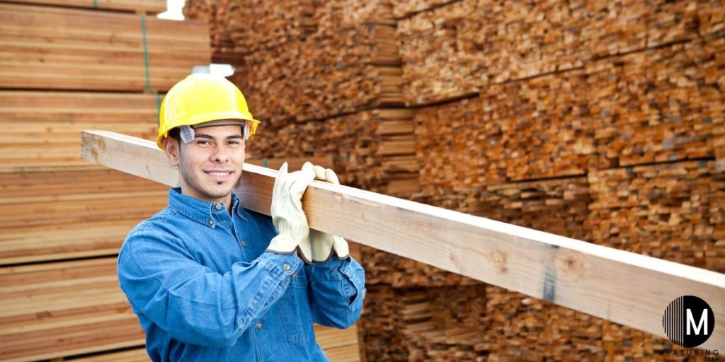 man carrying 2x4 board
