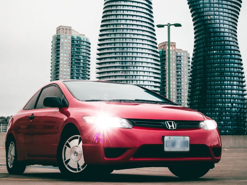 honda civic with bright lights and buildings in the background
