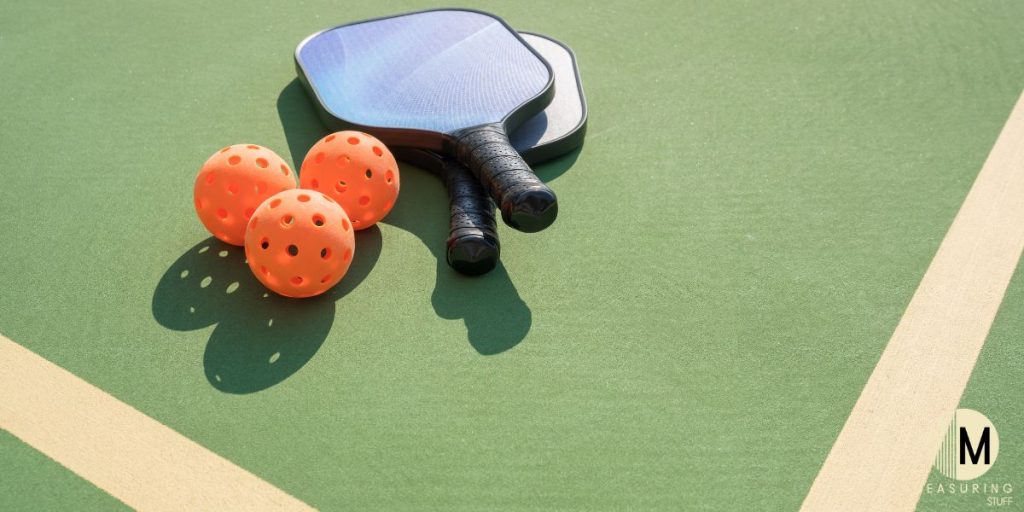 pickleballs with paddles