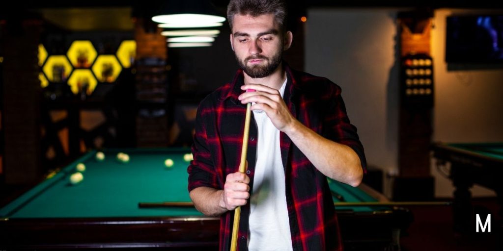 man putting chalk on pool cue