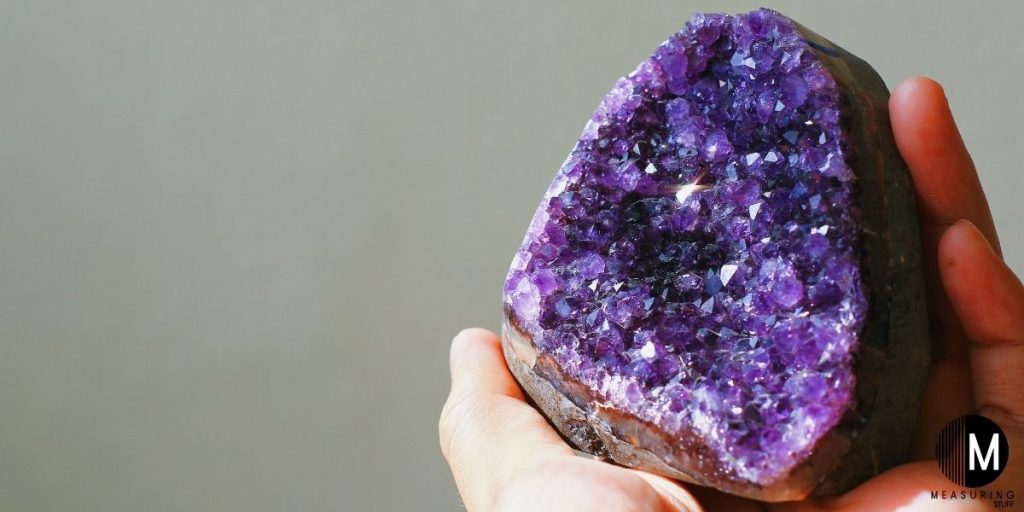 holding a purple amethyst stone