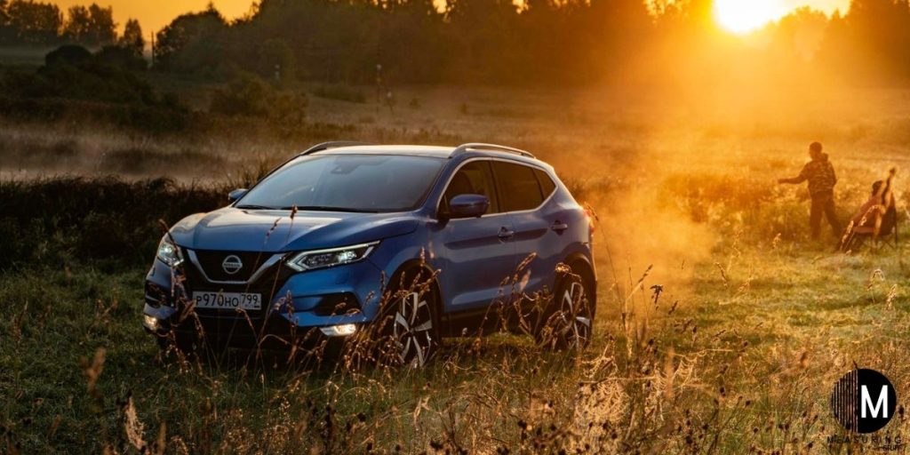 blue Nissan Rogue in a field