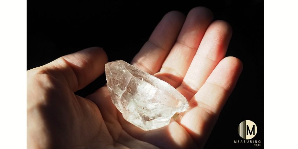 holding clear quartz crystal