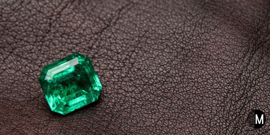 emerald gemstone on brown background
