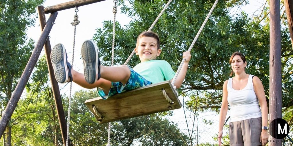 woman pushing child on swing