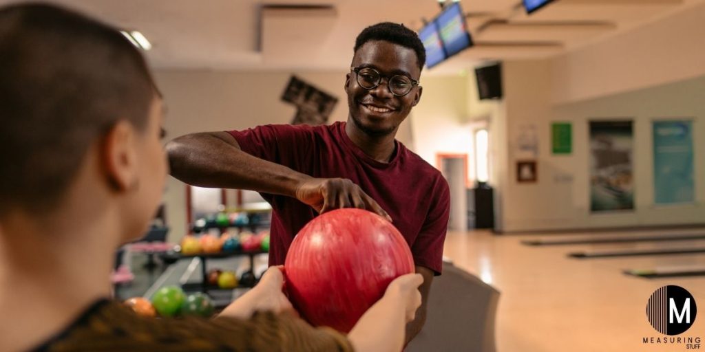 man trying a red bowling ball