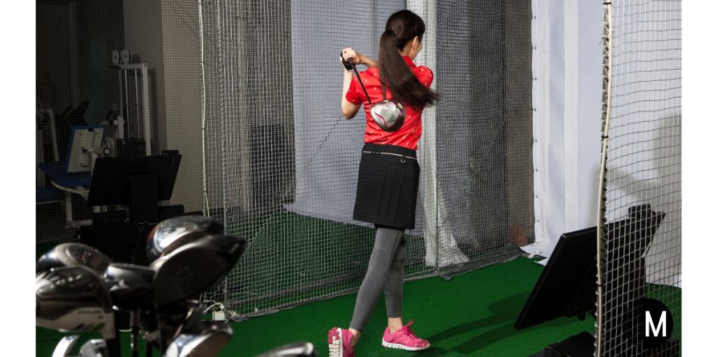 woman playing golf on a simulator