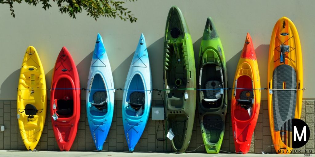 several kayaks leaning against a wall