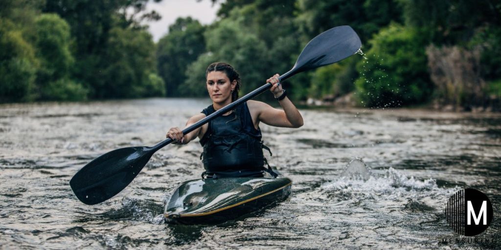 woman paddling a small kayak in rough water