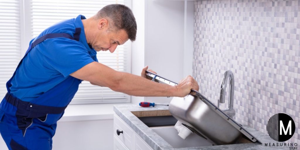 man installing a kitchen sink