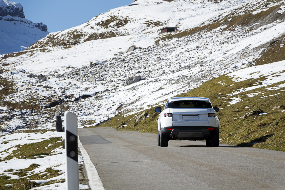 A car driving on a mountain road, could be used to show a driving adventure holiday