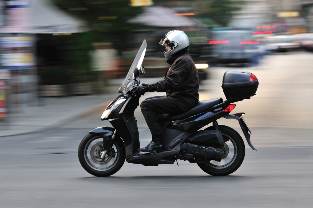Man ride a scooter in Budapest at main street. (panning camera for blur background)