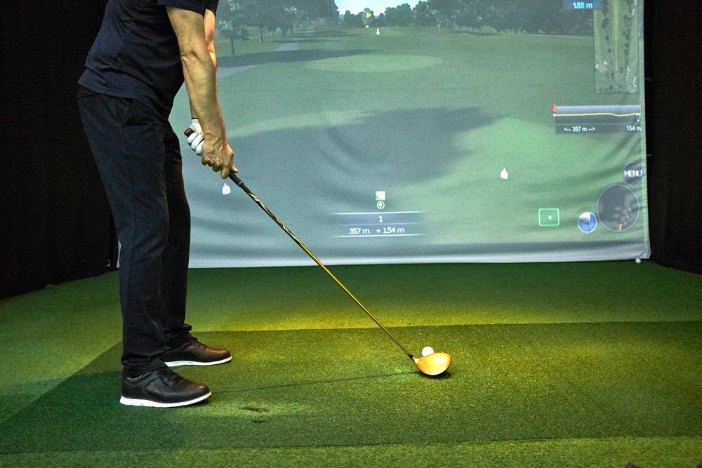 man hitting a tee shot on golf simulator
