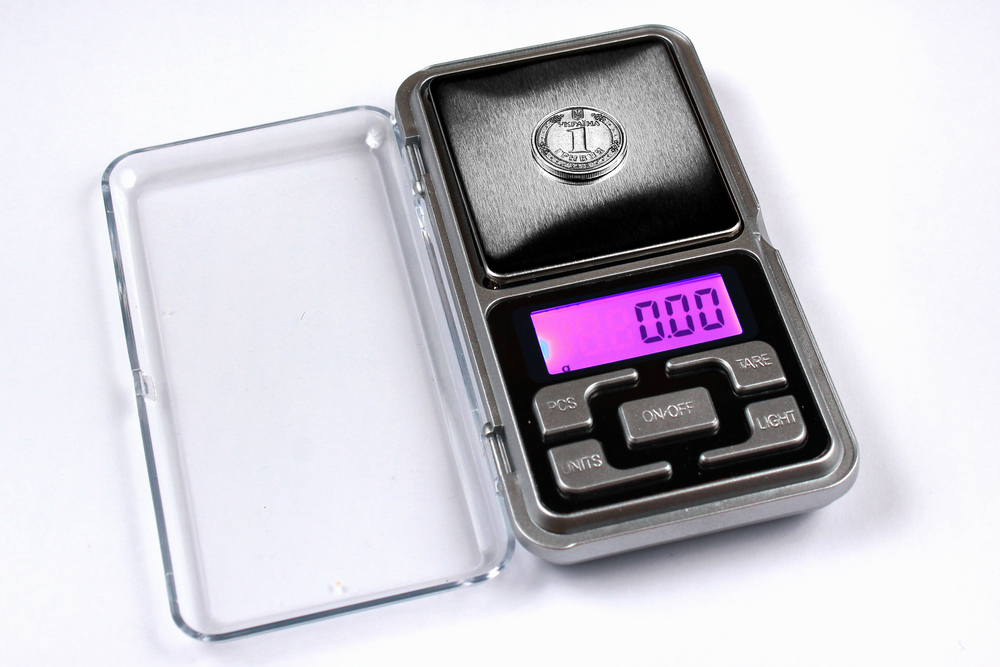 Ukrainian hryvnia coin on scales, shows zero weight. Currency inflation concept.