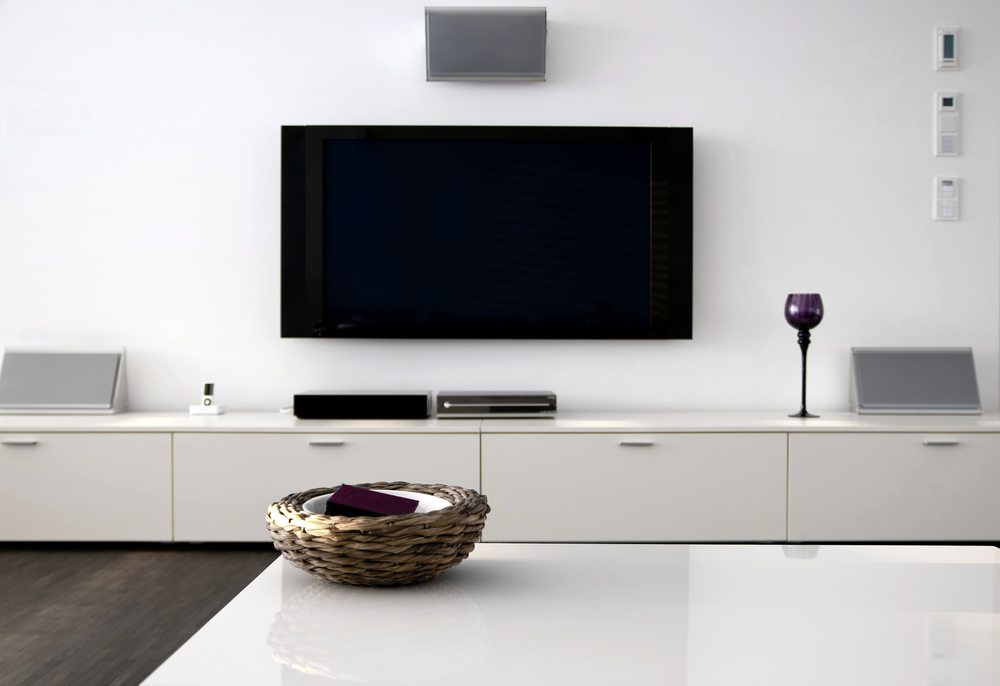 large flat screen tv wall mounted above a shelf