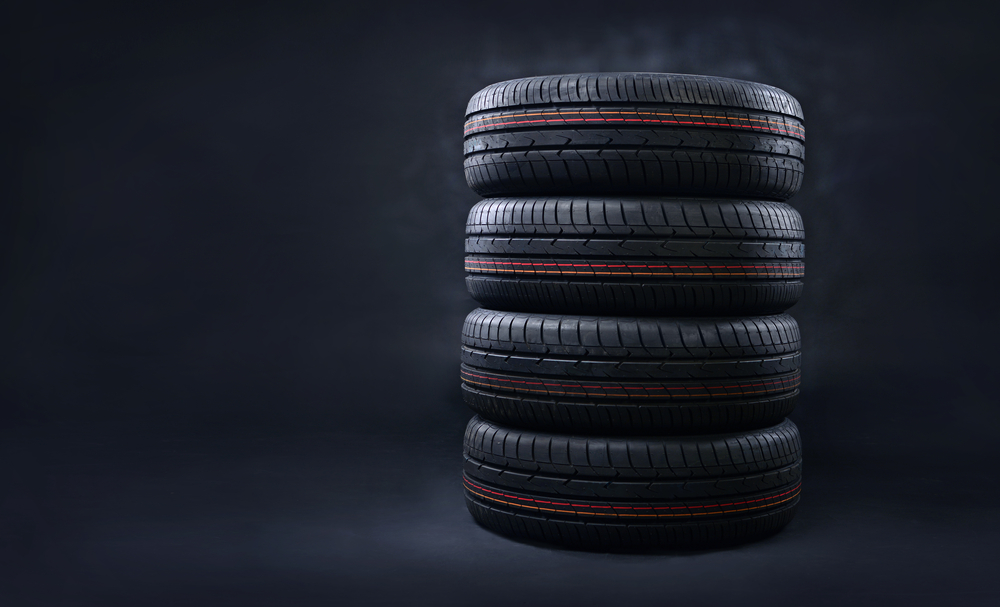 New radial tires pile on a dark background. Copy space.