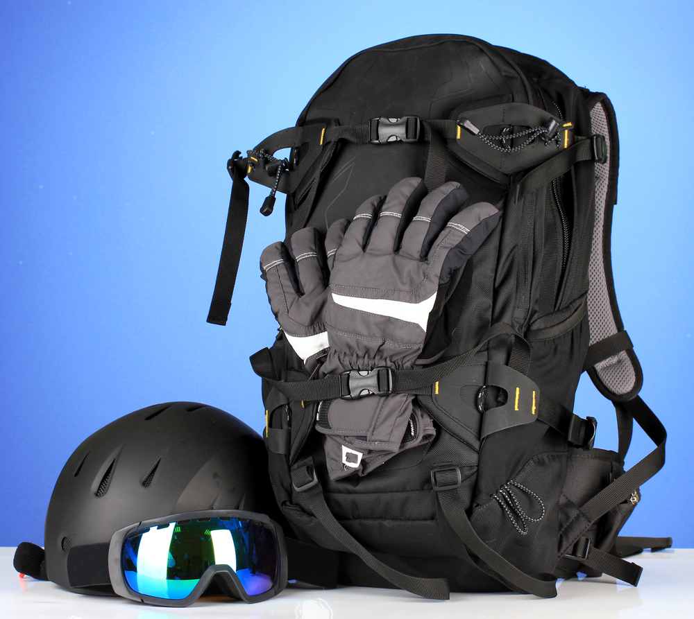 Winter sport glasses, helmet and gloves, backpack, on blue background
