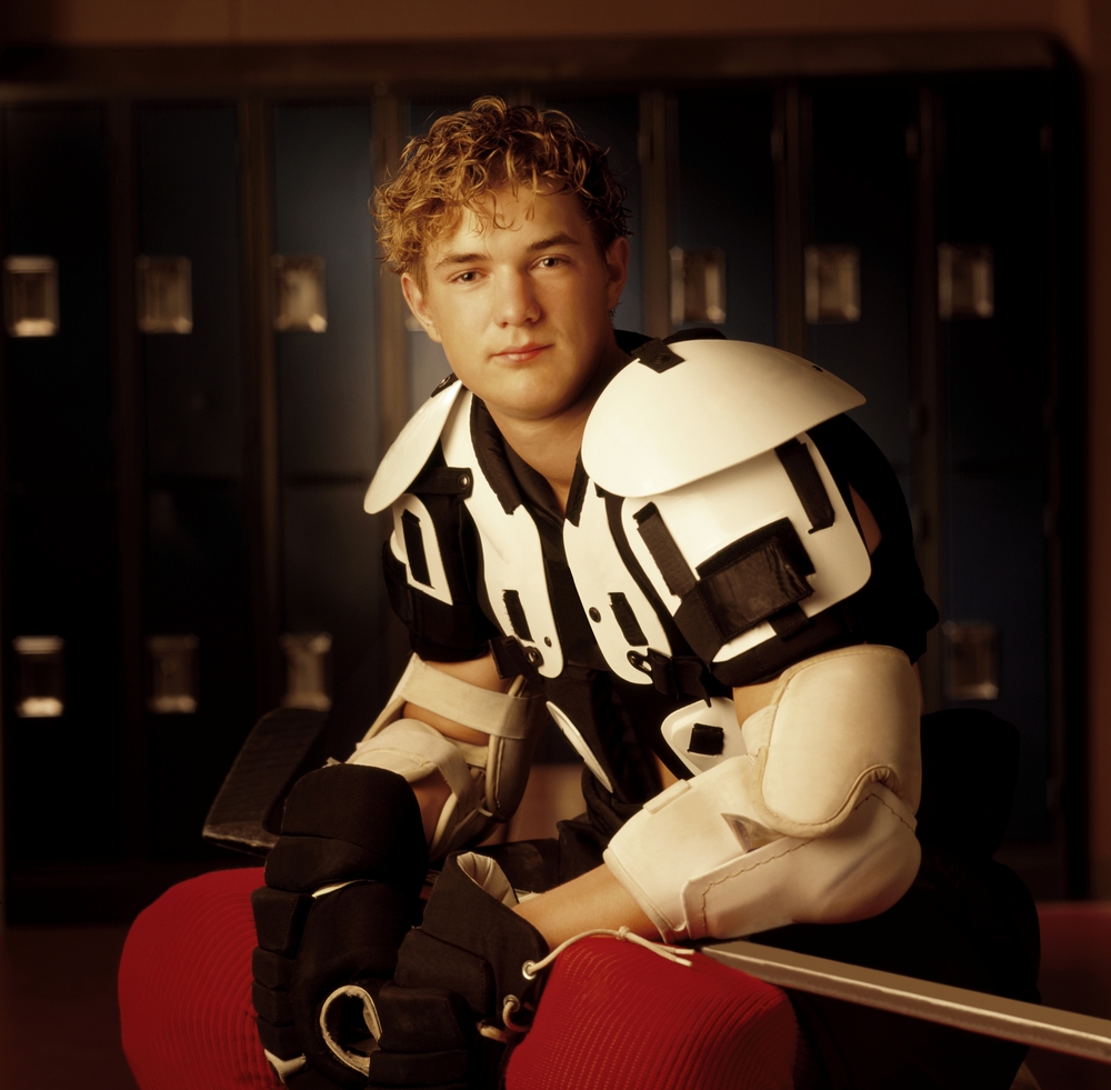 young male hockey player in dressing room
