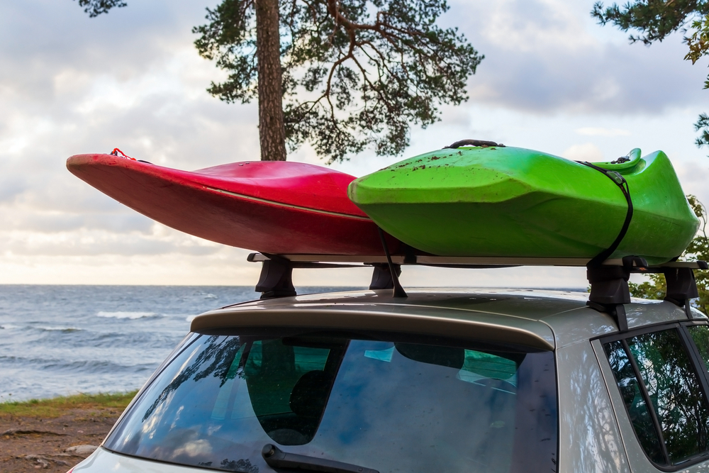 Car with a red and green kayak on the roof of the car