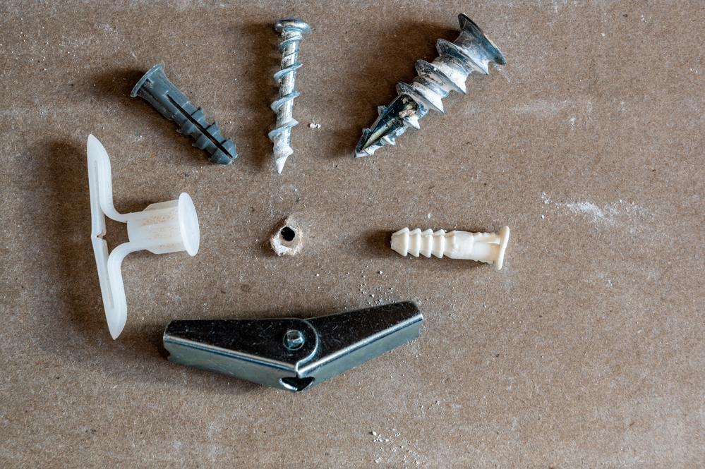 Various drywall anchors used in construction to hang objects on walls
