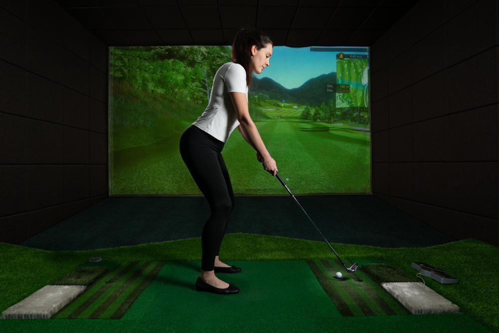 woman playing golf on a simulator