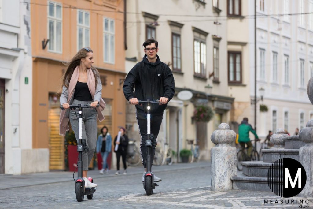 man and woman riding an escooter