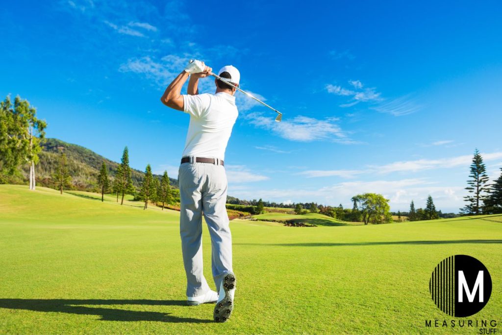 golf player swinging in fairway 