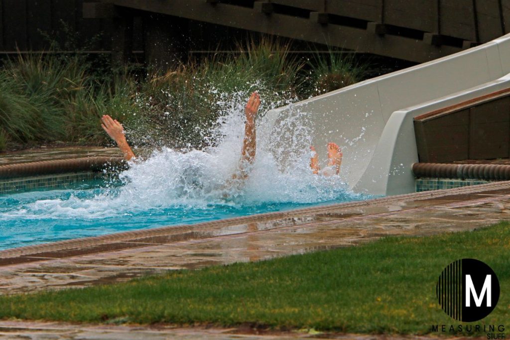 person splash landing in a pool from a water slide