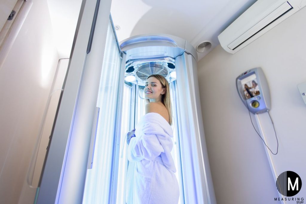 woman using a stand up tanning booth