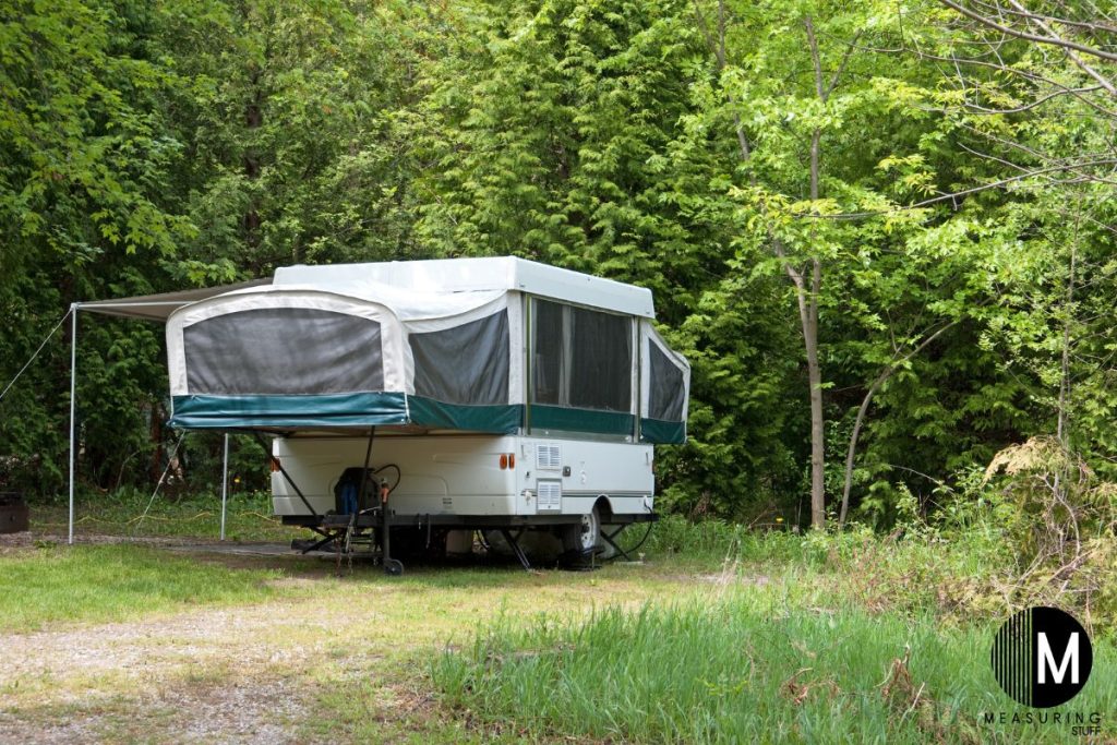 pop up camper parked on a wooded camping lot