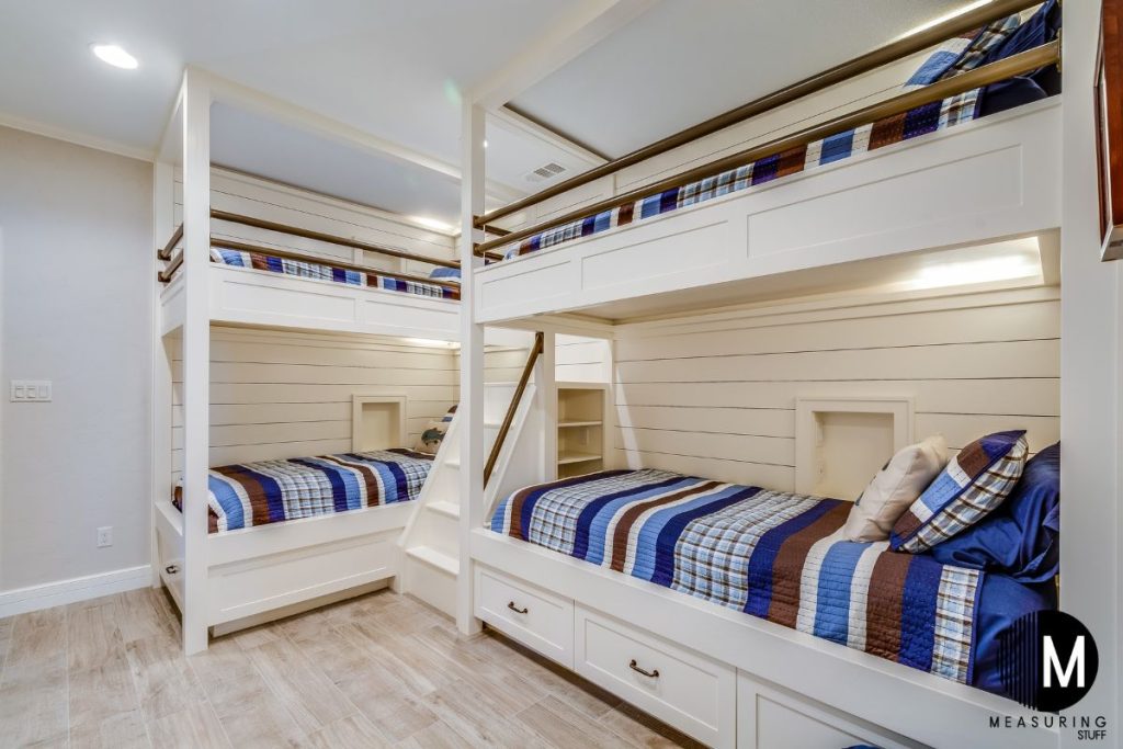 two bunk beds with pillows and blankets