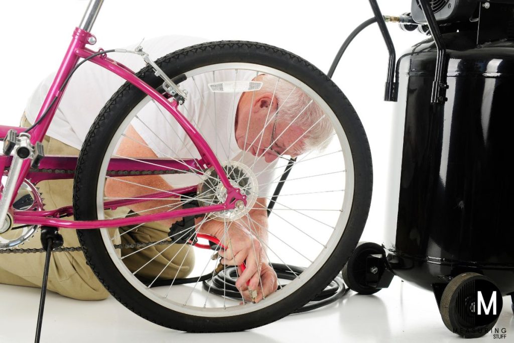 man putting air into a bike tire