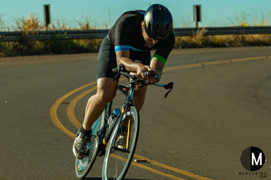 man going down hill on a racing bike