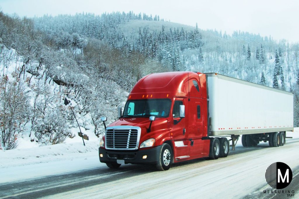 red semi truck driving in winter conditions
